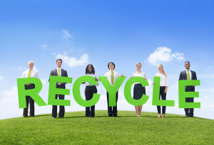 Business People Holding The Word Recycle on a Green Hill